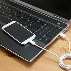Smartphone conectado al ordenador portátil a través de un cable USB