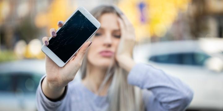 Mujer con el móvil roto que podrá solucionarlo gracias a un seguro de móvil